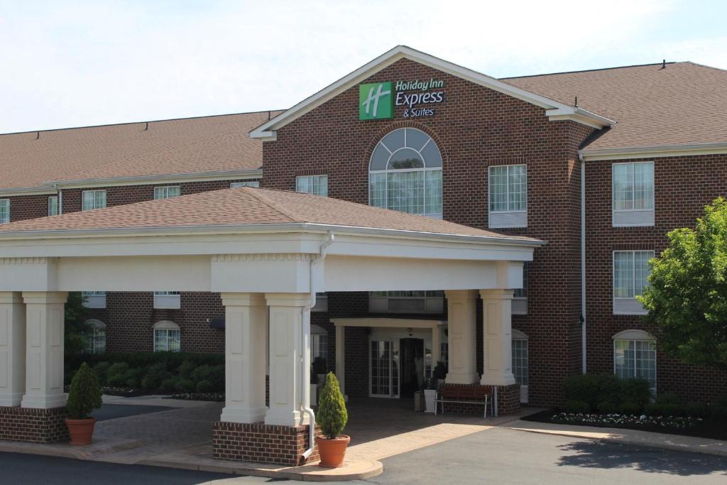 un gran edificio de ladrillo con un cartel. en Holiday Inn Express Hotel & Suites Warrenton, an IHG Hotel, en Warrenton