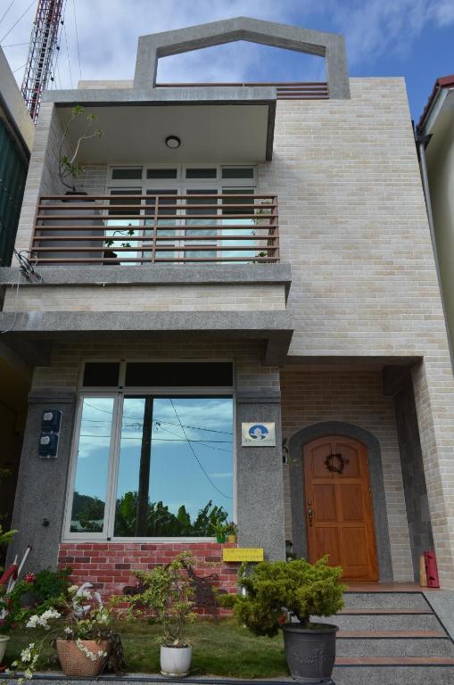 Casa con balcón y puerta de madera en Kivala Home, en Shoufeng