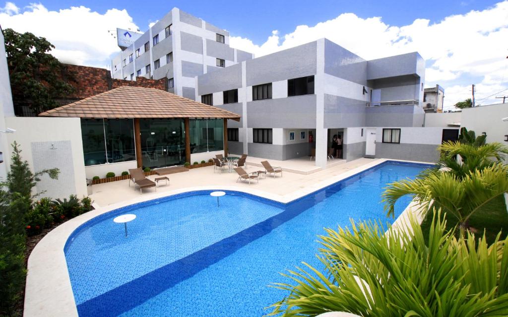 una casa con piscina frente a ella en Camaçari Plaza Hotel, en Camaçari