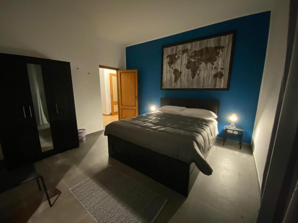 a bedroom with a bed and a blue wall at Campobasso 30E in Campobasso