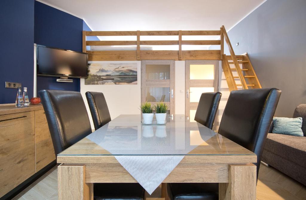 a dining room with a table and chairs at Apartamenty Plażowa 11 in Darłówko