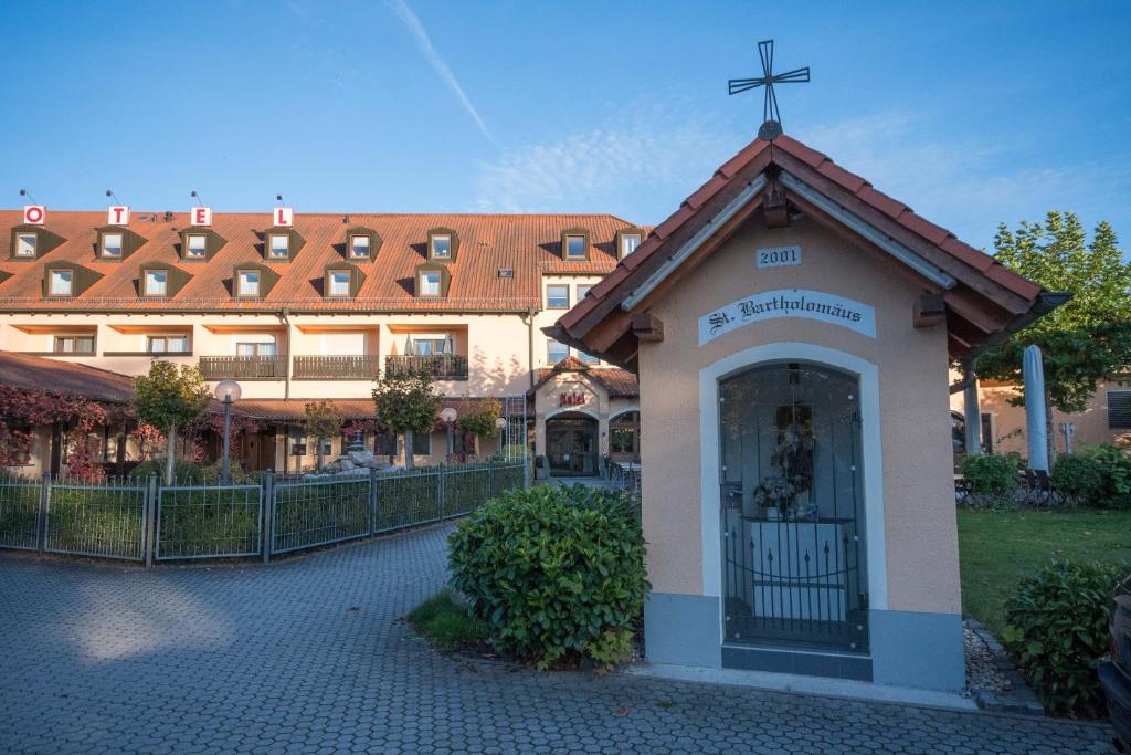 uma igreja com uma cruz no topo de um edifício em Hotel Bartholomäus em Zeitlarn