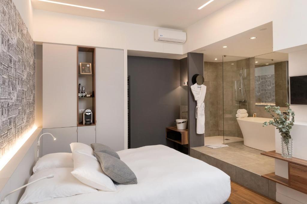 a bedroom with a white bed and a bathroom at MiHotel Bizolon in Lyon