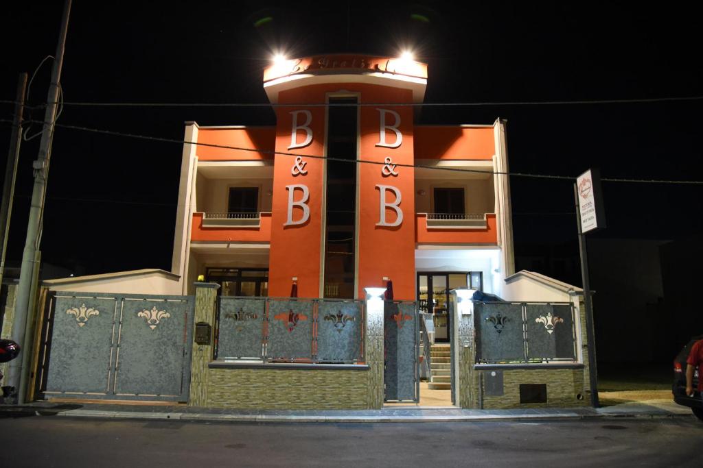 a building with a large sign on it at night at B&B La Graticola Ristorante Pizzeria in Trepuzzi