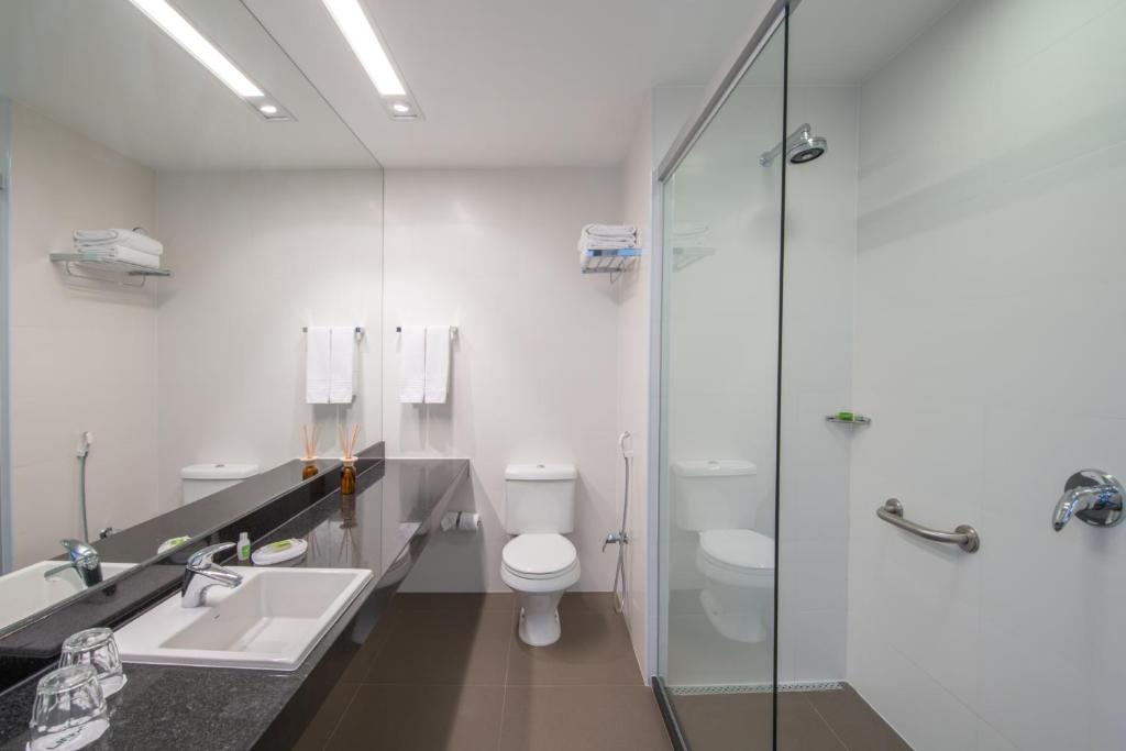 a bathroom with a toilet and a sink and a shower at Linx Galeão in Rio de Janeiro