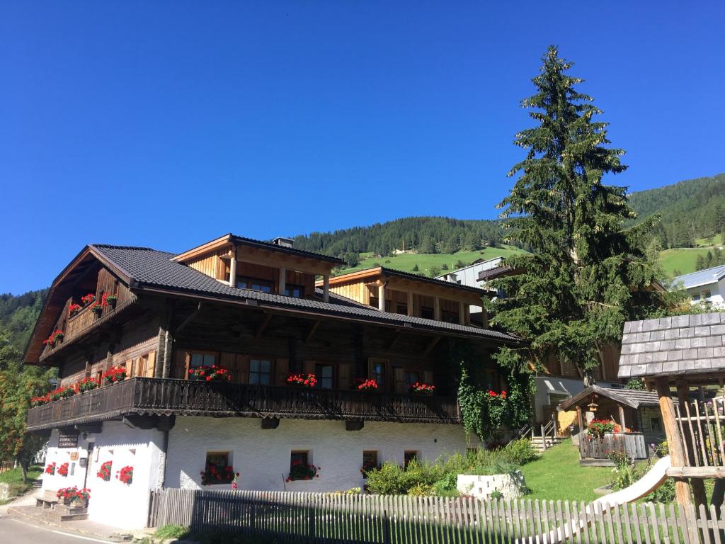 a house with a balcony and a tree at Unteradamerhof in Sesto