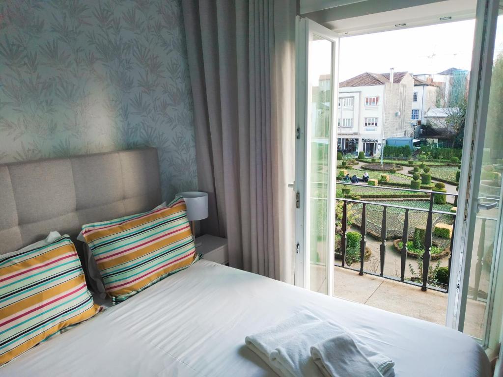 a bedroom with a bed with a view of a balcony at Braga Center Apartments - Eça de Queirós in Braga