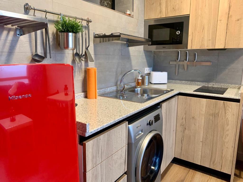 uma cozinha com um frigorífico vermelho e uma máquina de lavar roupa em Loft Desing Retiro em Madrid