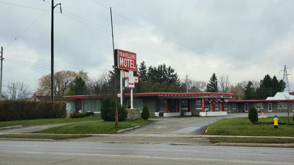 a motel sign in front of a gas station at Travellers Motel in Stratford