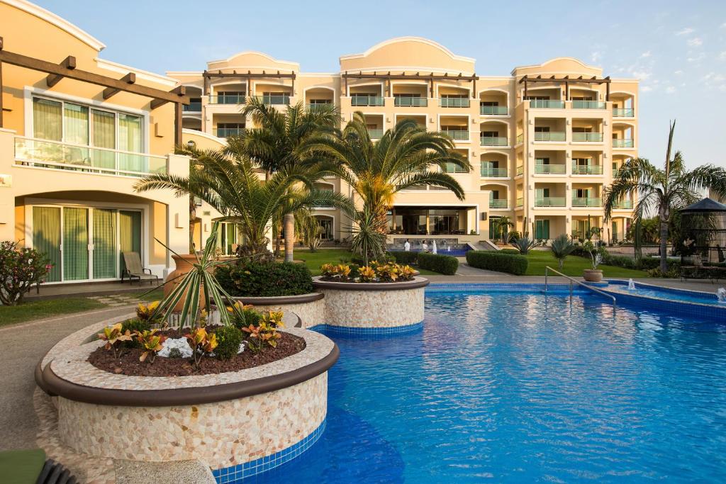 um hotel com piscina em frente a um edifício em Diamond Bay em Mazatlán