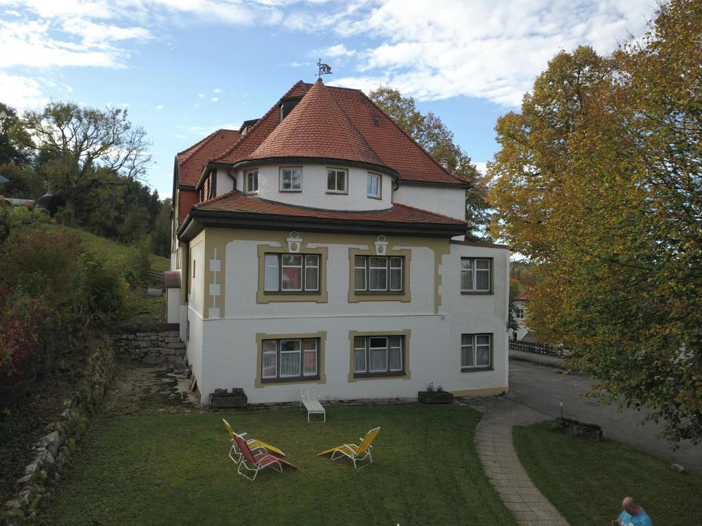 a large house with two chairs in the yard at Villa am Park in Bad Tölz