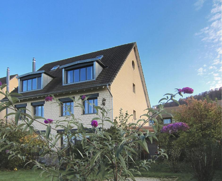 ein Haus mit Fenstern und Blumen davor in der Unterkunft B&B Bättwil in Bättwil