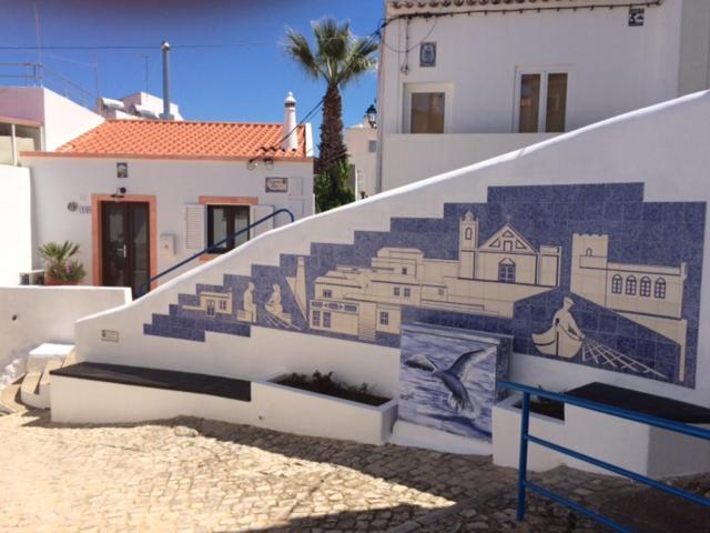a staircase with a mural on the side of a building at Casa do Gato in Ferragudo