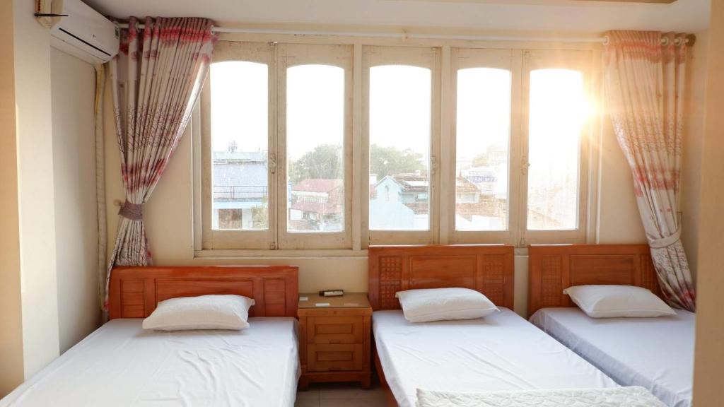 2 Betten in einem Zimmer mit 2 Fenstern in der Unterkunft 89 Hotel in Cao Bằng