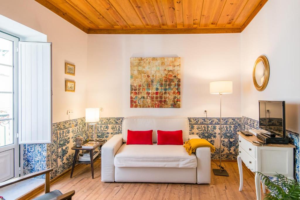 リスボンにあるSantos Typical and Cosy Apartmentsのリビングルーム(白いソファ、赤い枕付)