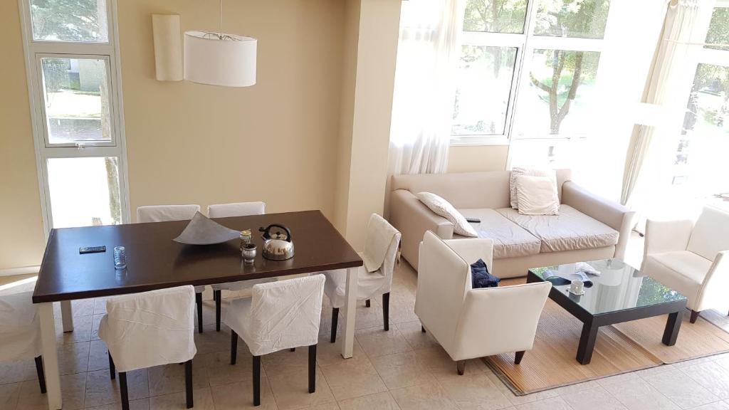a dining room with a table and chairs and a couch at Terrazas de Carilo 1A in Carilo