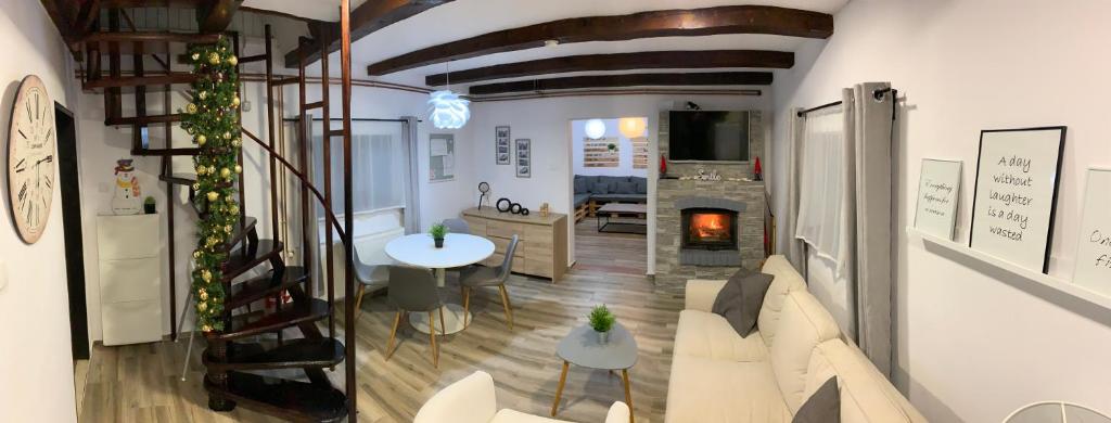 a living room with a white couch and a fireplace at Holiday Home Međimurski Raj in Štrigova