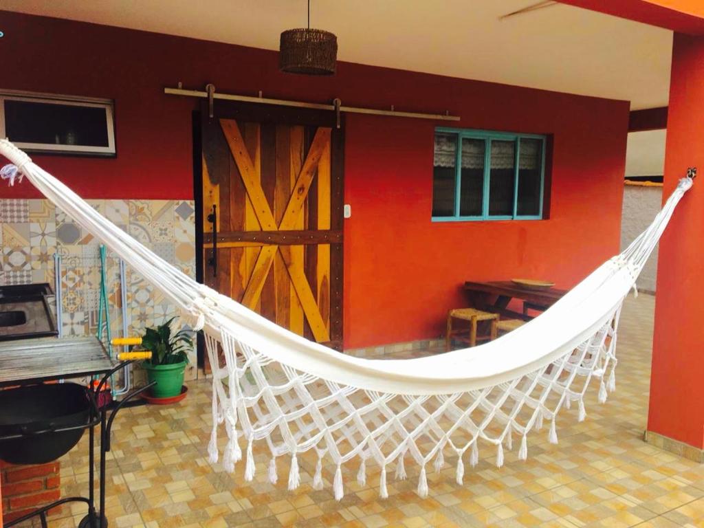 a hammock in a room with a red wall at Aconchego e conforto em Joanópolis in Joanópolis