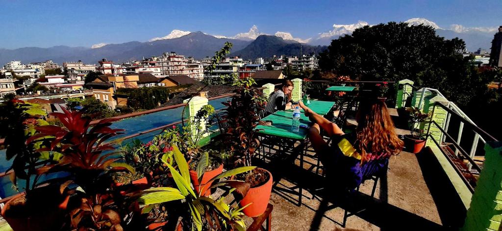 a woman laying on a balcony next to a swimming pool at Kiwi Backpackers Hostel Pokhara in Pokhara