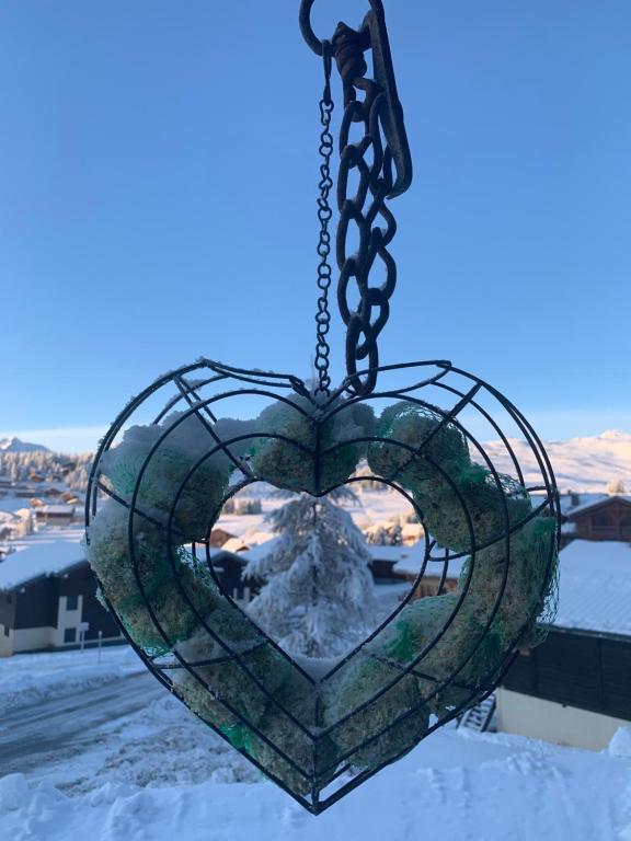 a heart shaped window hanging from a chain at APPARTEMENT PLEIN SUD AUX SAISIES N°6 in Les Saisies
