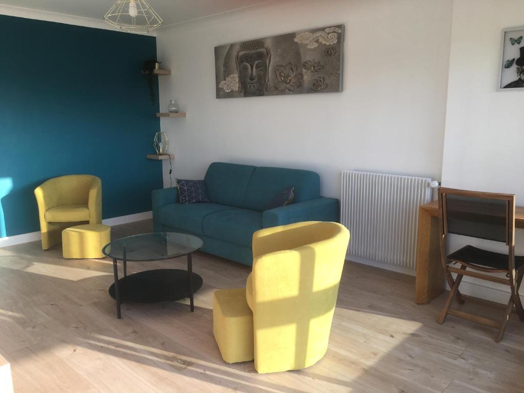 a living room with a blue couch and yellow chairs at T2 hyper centre bord de Loire Parking in Nantes