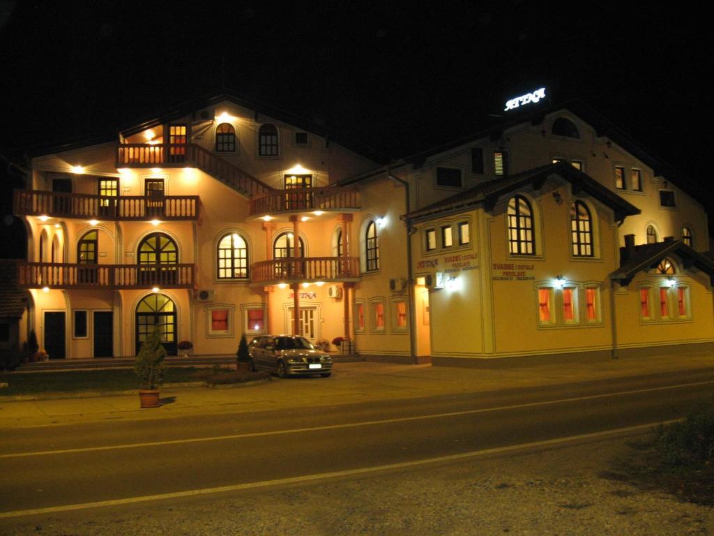 un edificio con un'auto parcheggiata di fronte ad esso di notte di Villa Atina a Stara Pazova