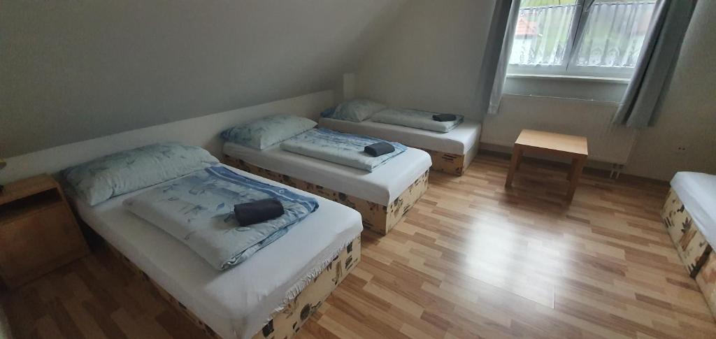 3 łóżka w pokoju z drewnianą podłogą w obiekcie Pod Vinicí w mieście Mikulov