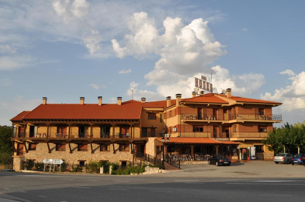 um grande edifício com um telhado vermelho numa rua em Hotel Langa em Cerezo de Abajo