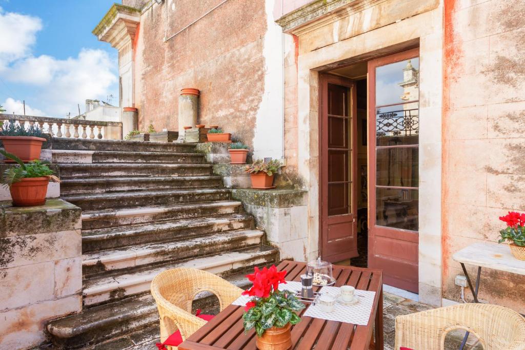 patio con tavolo, sedie e scale di La terrazza sulla Chiesa di San Francesco d'Assisi a Castellana Grotte