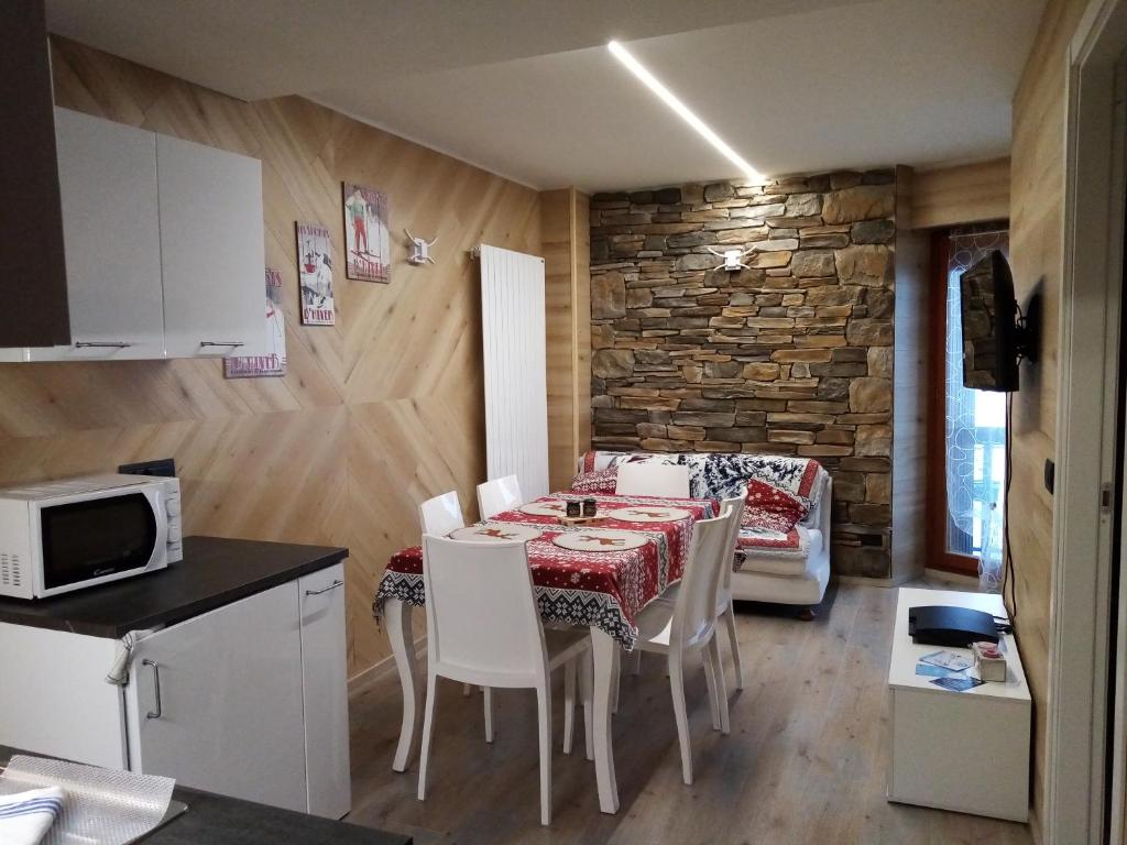 a kitchen and dining room with a table and chairs at Le stelle 1400 - Cabanaira Condominio in Limone Piemonte