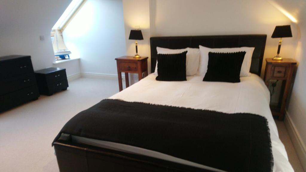 a bedroom with a black and white bed with two lamps at 10 The Kiln in Westport