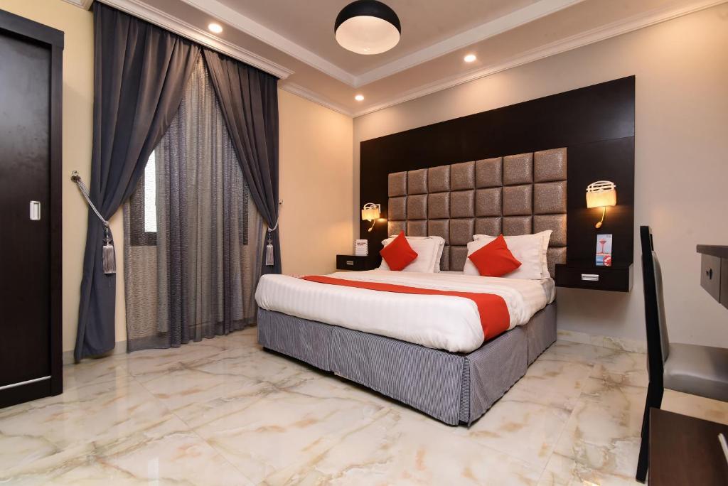 a hotel room with a large bed with red pillows at Durra Taraf 1 Residential in Dammam