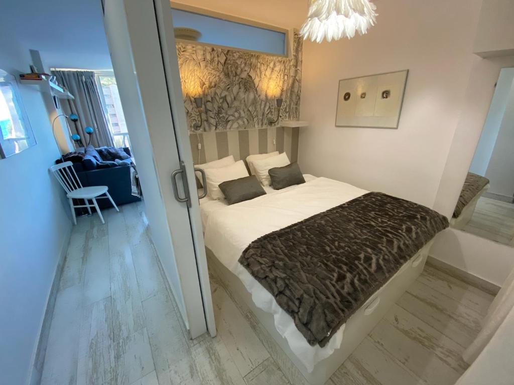 ein Schlafzimmer mit einem Bett und einem Stuhl in einem Zimmer in der Unterkunft Apartment Susanne in Benidorm