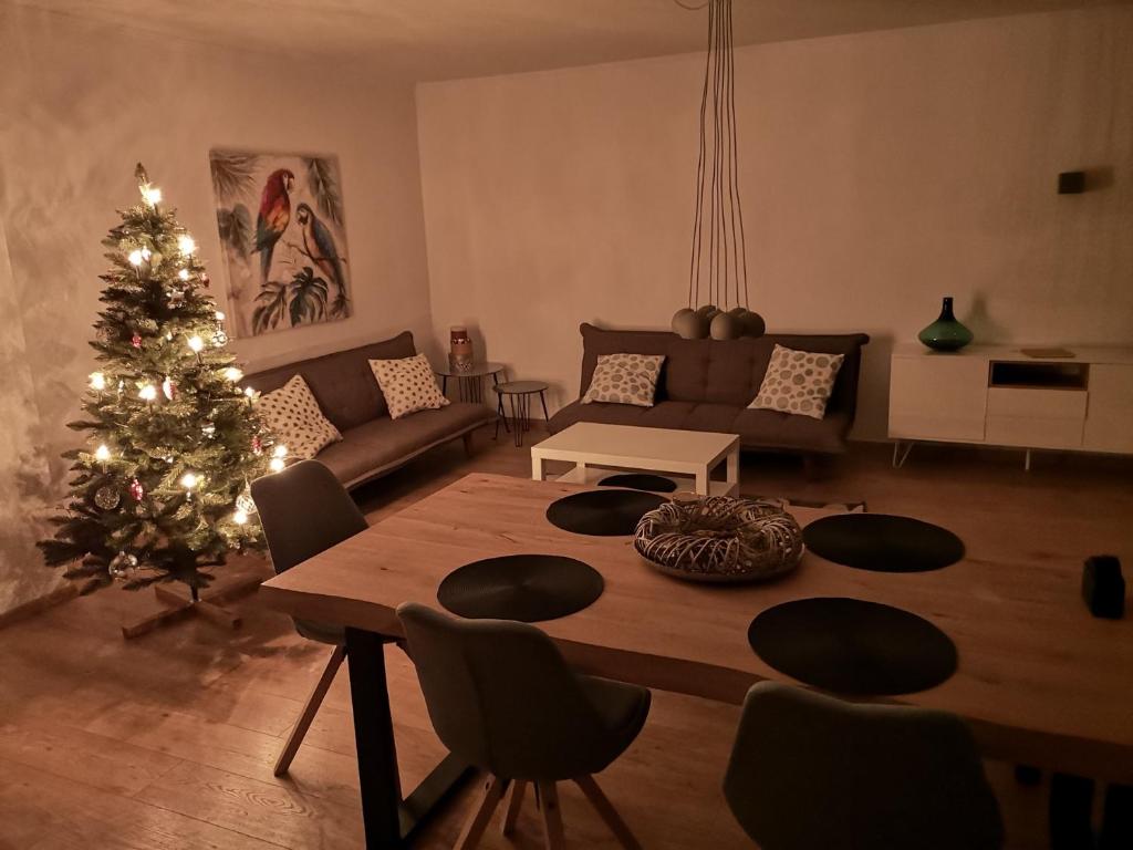 un salon avec un arbre de Noël et une table dans l'établissement Ferienwohnung Contrescarpe City, à Brême