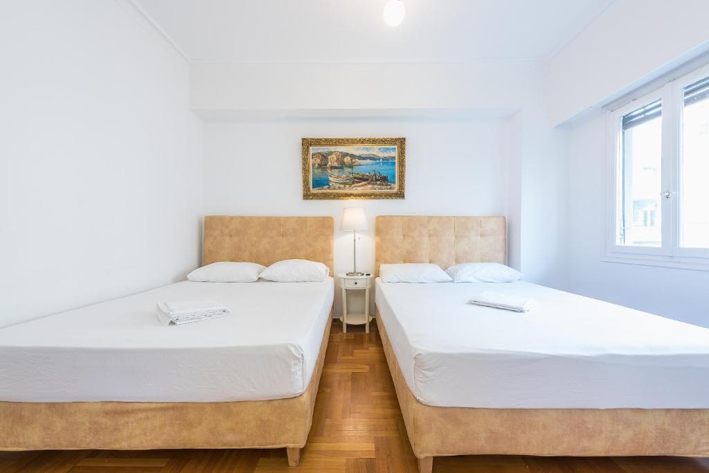 A bed or beds in a room at Victoria Queens Suites Apartments