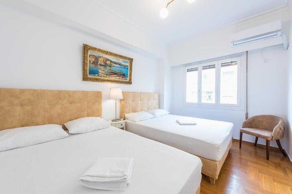 A bed or beds in a room at Victoria Queens Suites Apartments