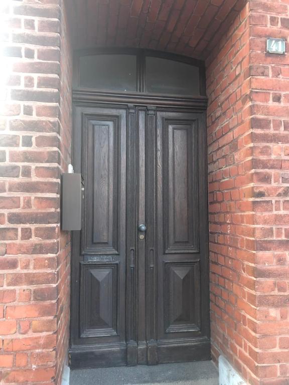 a black door in a brick building with a brick wall at Apartment 1 in Korschenbroich