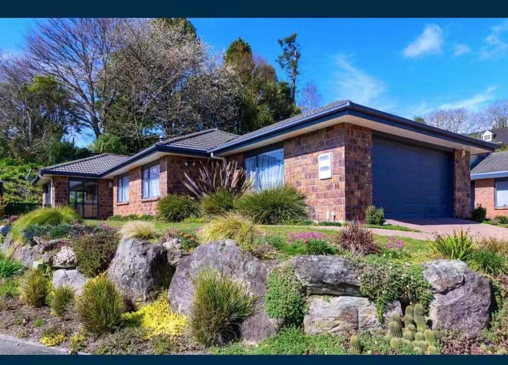 a brick house with a rock garden at Sweet Home in Rotorua