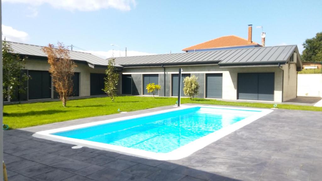 - une piscine en face d'une maison dans l'établissement Carballos Altos-Apartamentos Turísticos, à Arzúa