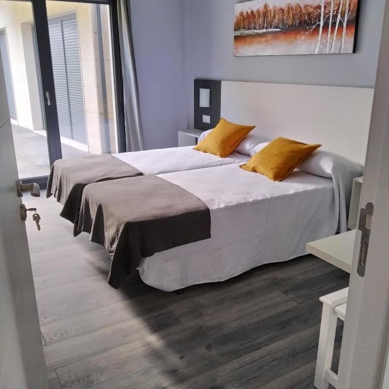 A bed or beds in a room at Carballos Altos-Apartamentos Turísticos
