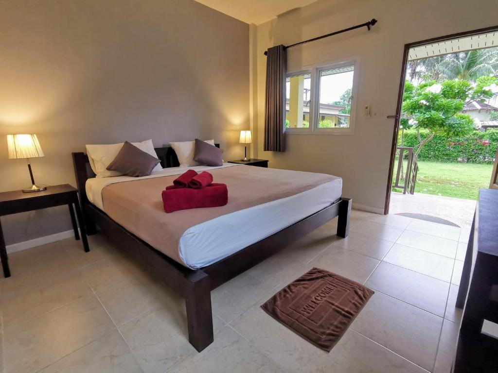 ein Schlafzimmer mit einem Bett mit einer roten Schleife darauf in der Unterkunft SER-EN-DIP-I-TY - SHA Extra Plus in Ko Lanta