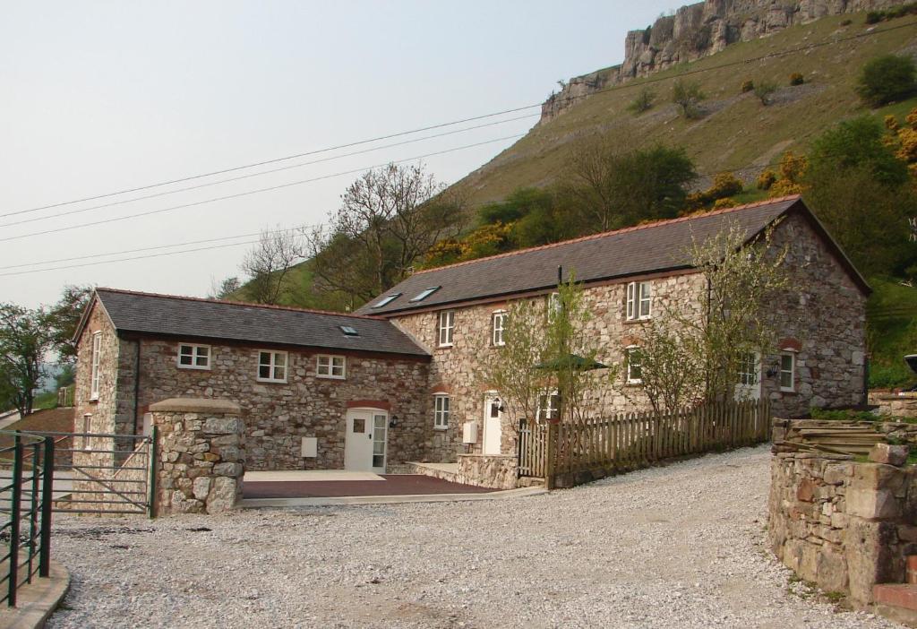 蘭戈倫的住宿－全景小屋酒店，一座古老的石头建筑,后面有一座小山