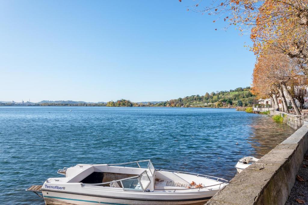 una barca è ormeggiata in un molo su un lago di Le tre Ninfee di Pusiano! Free Parking a Pusiano