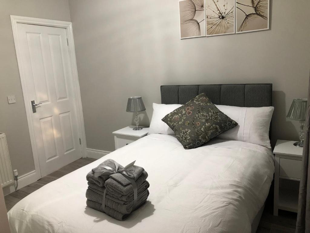 1 dormitorio con 1 cama blanca y 2 mesitas de noche en Beechwood Garden Suite, en Newtownabbey