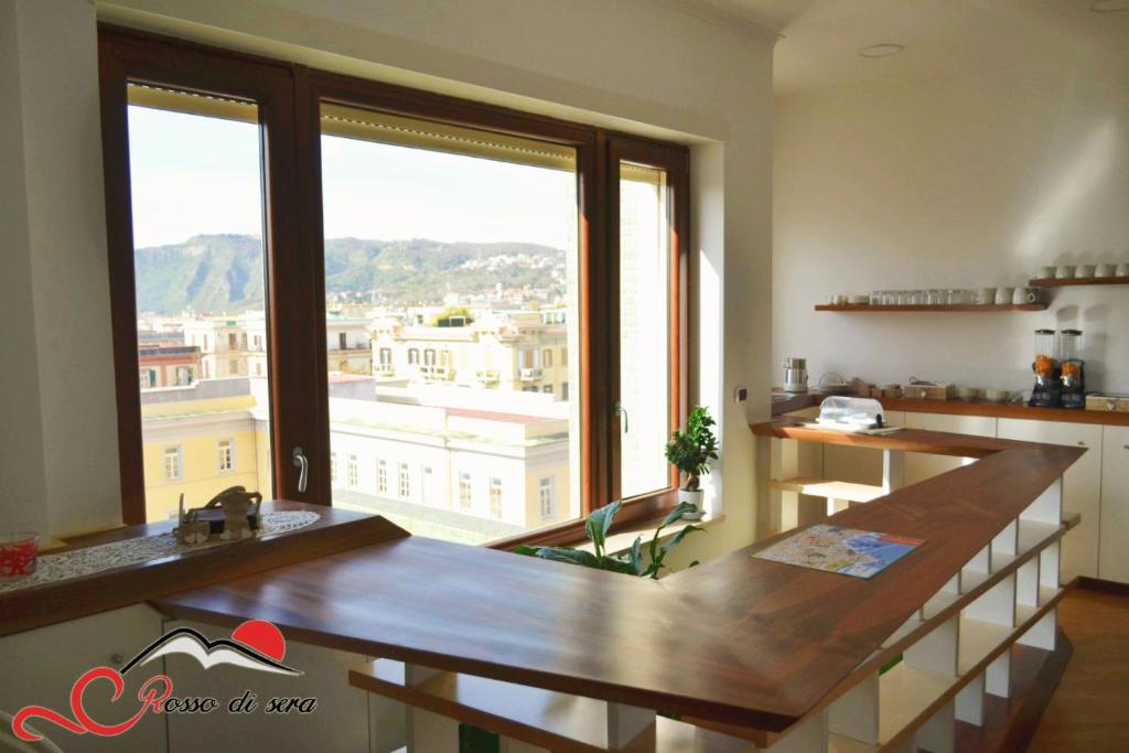 a kitchen with a table and a large window at Rosso di sera in Naples