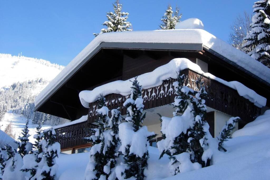 ein schneebedecktes Haus mit Balkon im Schnee in der Unterkunft Chalet Les Erines in Châtel