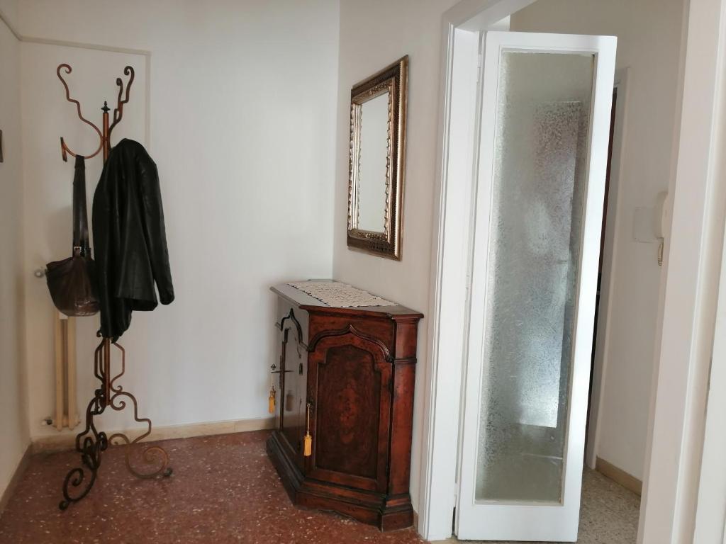 Habitación con armario de madera y espejo. en Appartamento Beatrice, en Pistoia
