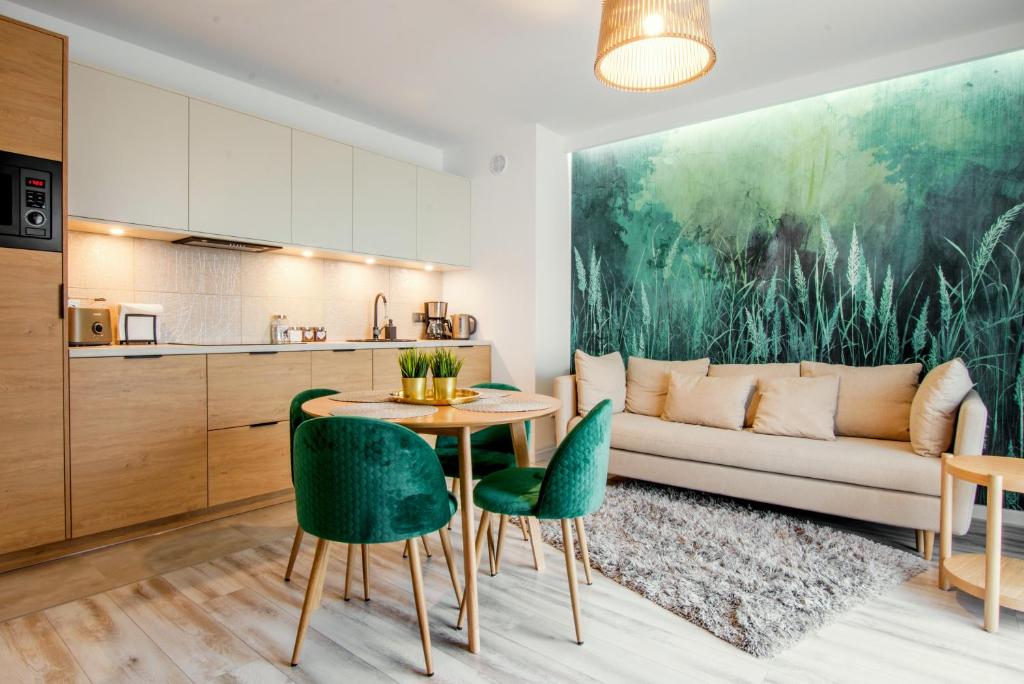 sala de estar con sofá, mesa y sillas en W&K Apartments - Green Suite, en Koszalin