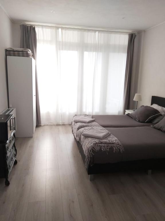 a bedroom with a bed and a large window at Studio Slijterij Zandvoort in Zandvoort