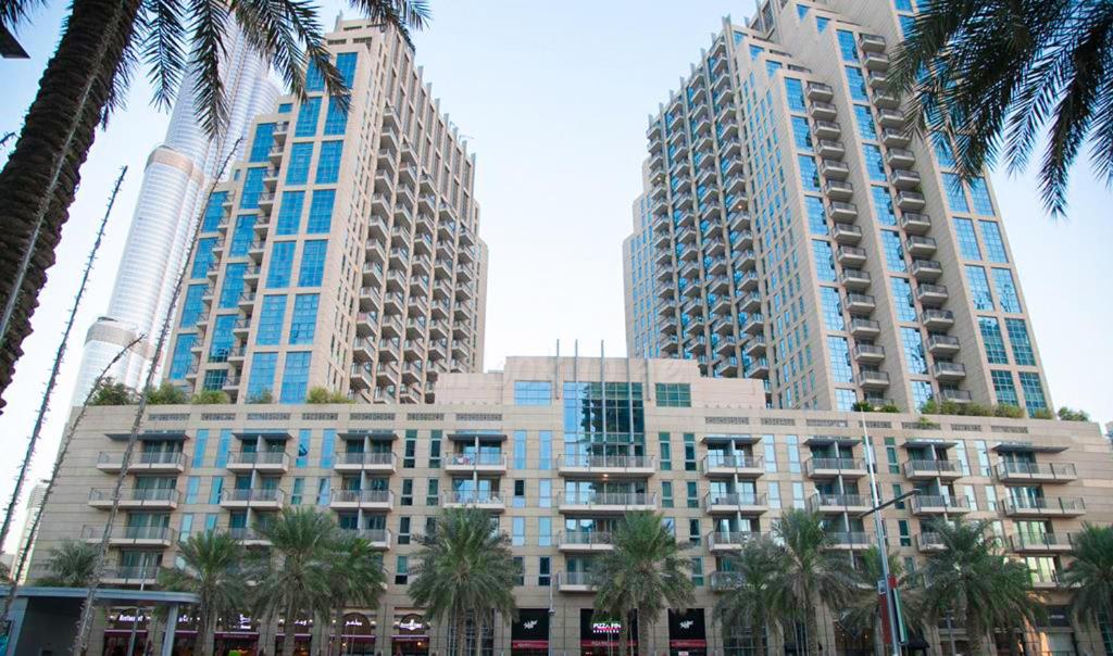 a building with palm trees in front of tall buildings at OYO 398 Home Standpoint Tower A , 1 BR in Dubai